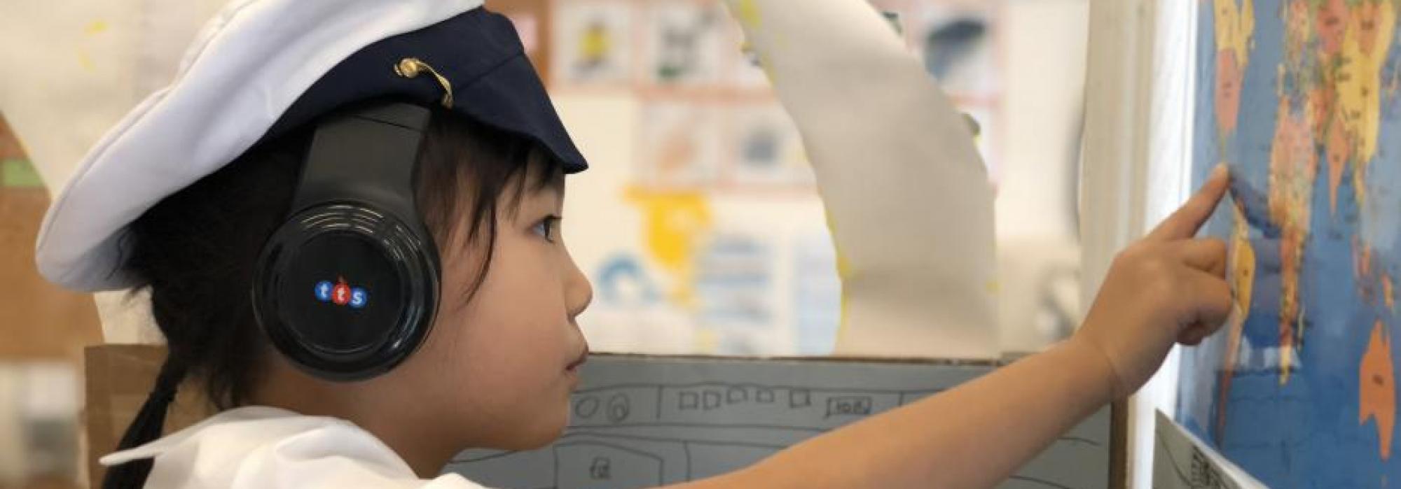 A young child pointing to a map