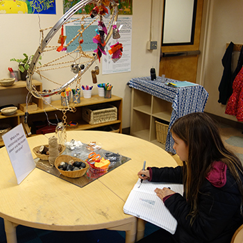 Student analyzing objects on a desk.