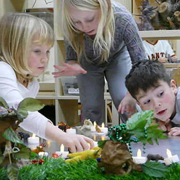 Students playing with pretend candles and plants.