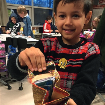 Boy showing off a wallet made from paper.