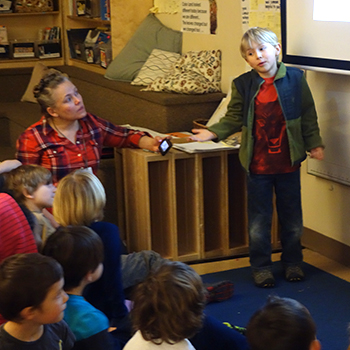 Young student presenting in front of peers.