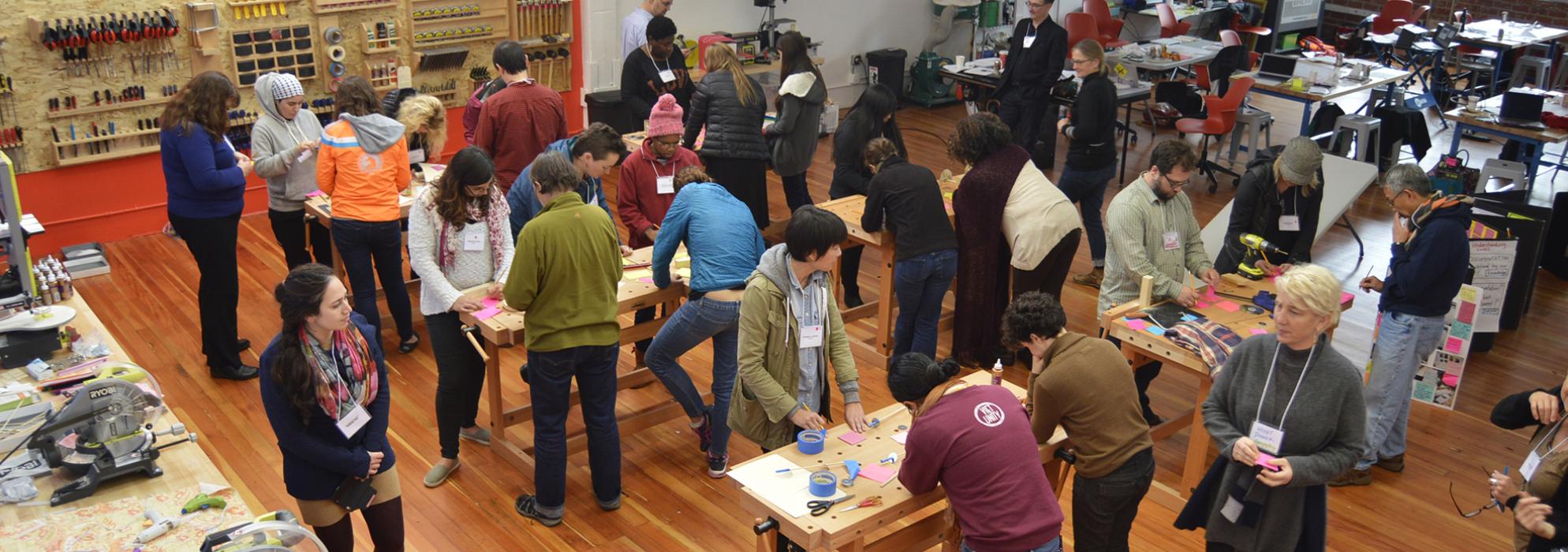 A group of adult leaners working at several tables making with various materials