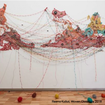 An artwork titled Woven Chronicle (2018) by Reena Kallat, featuring a world map created using intertwined colored threads and electrical wires.