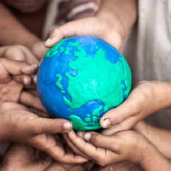 close-up photograph of multiple hands holding a small model of the Earth.